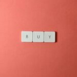 Keyboard keys spelling 'BUY' on a coral background, ideal for e-commerce themes.