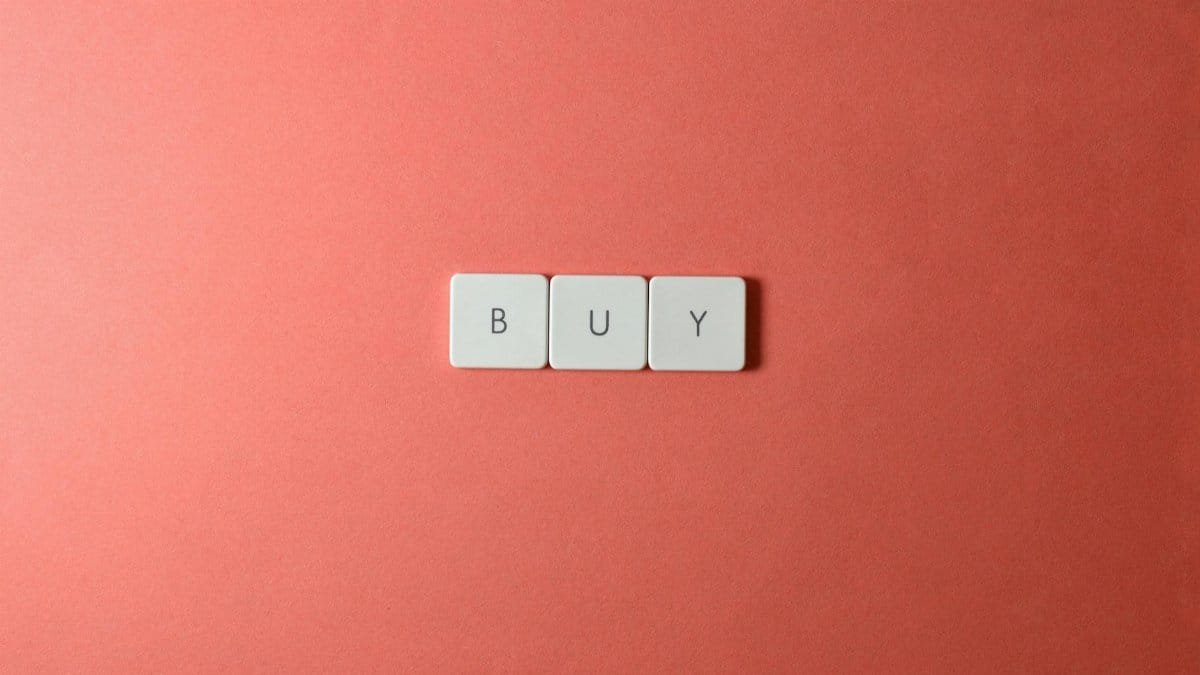 Keyboard keys spelling 'BUY' on a coral background, ideal for e-commerce themes.