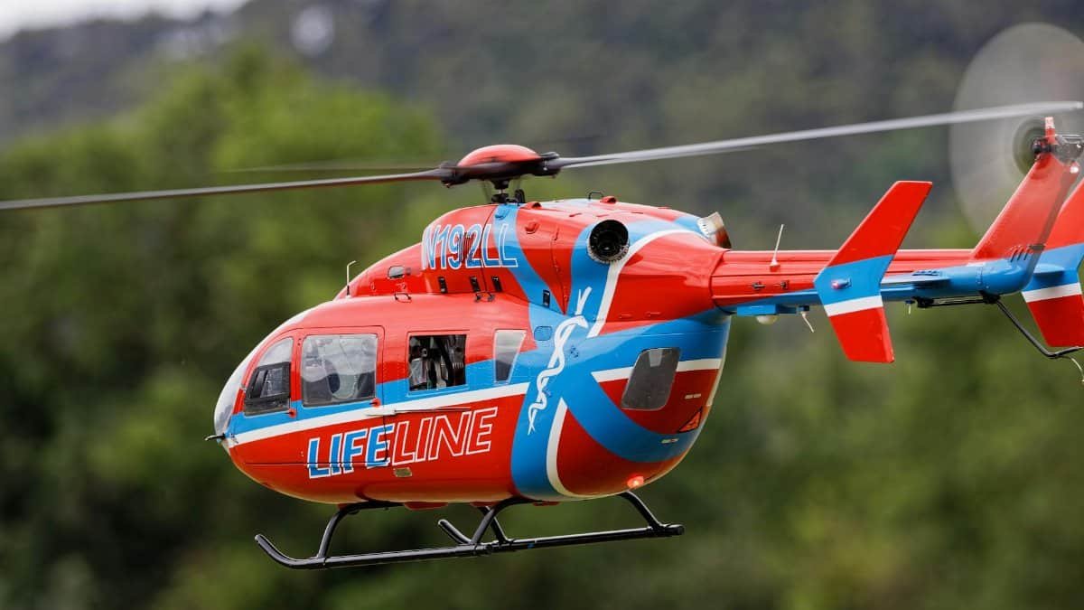 Close-up of a Lifeline helicopter in flight, showcasing its bold red and blue design.