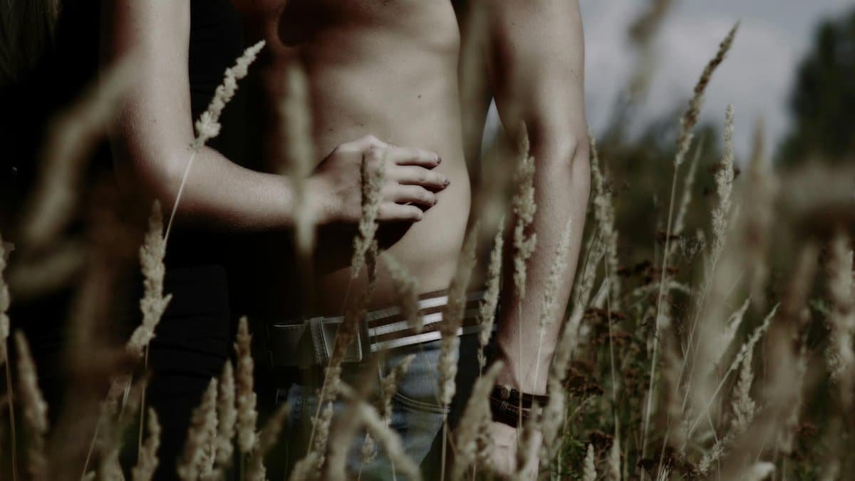 A couple embracing in a field, highlighting intimacy and connection.