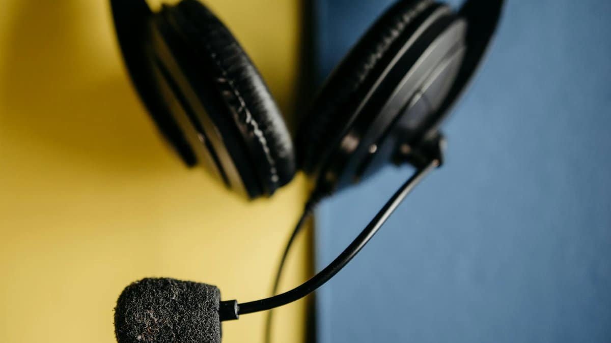 A detailed view of a black headset with microphone on a blue and yellow background, ideal for tech themes.