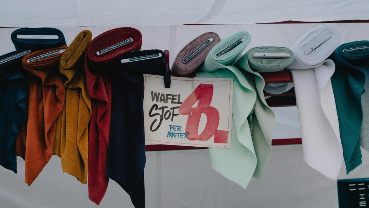 Vibrant waffle fabric rolls for sale at a street market in Maastricht, Netherlands.