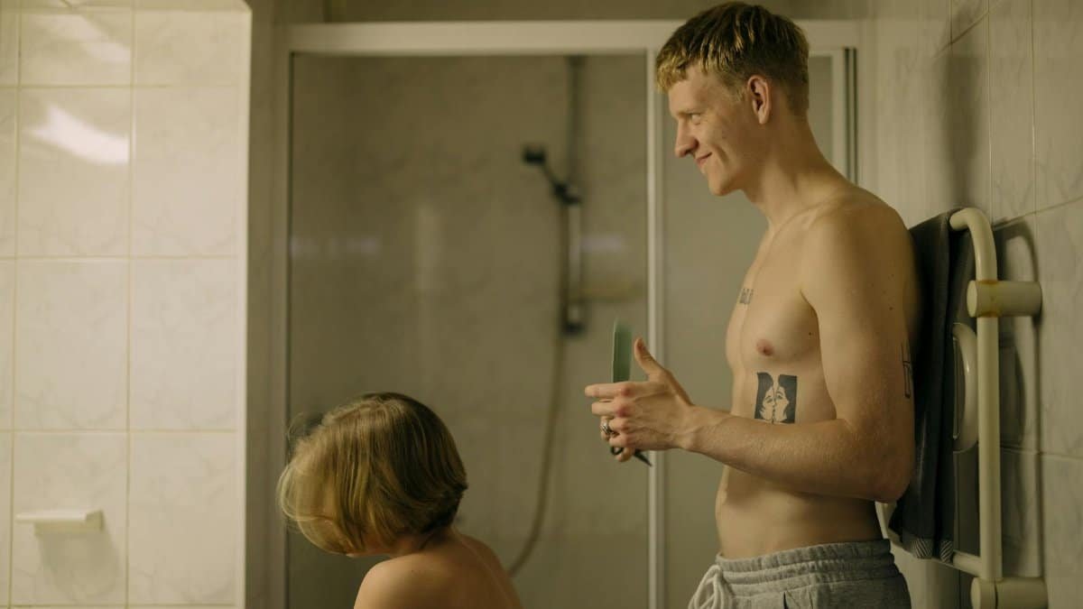 Man giving a haircut to a family member in an intimate bathroom setting.