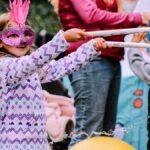 Young girl enjoying a playful water activity at an outdoor festival in Wheeling, WV.