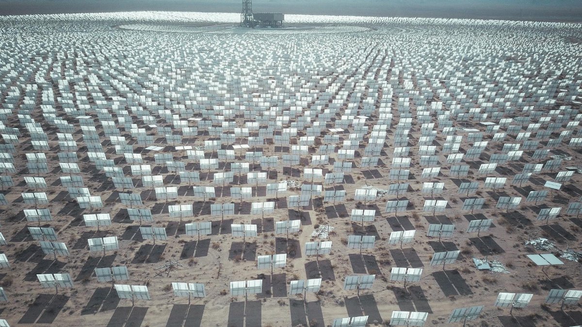 Aerial view of expansive solar panel array in a desert landscape generating renewable energy.