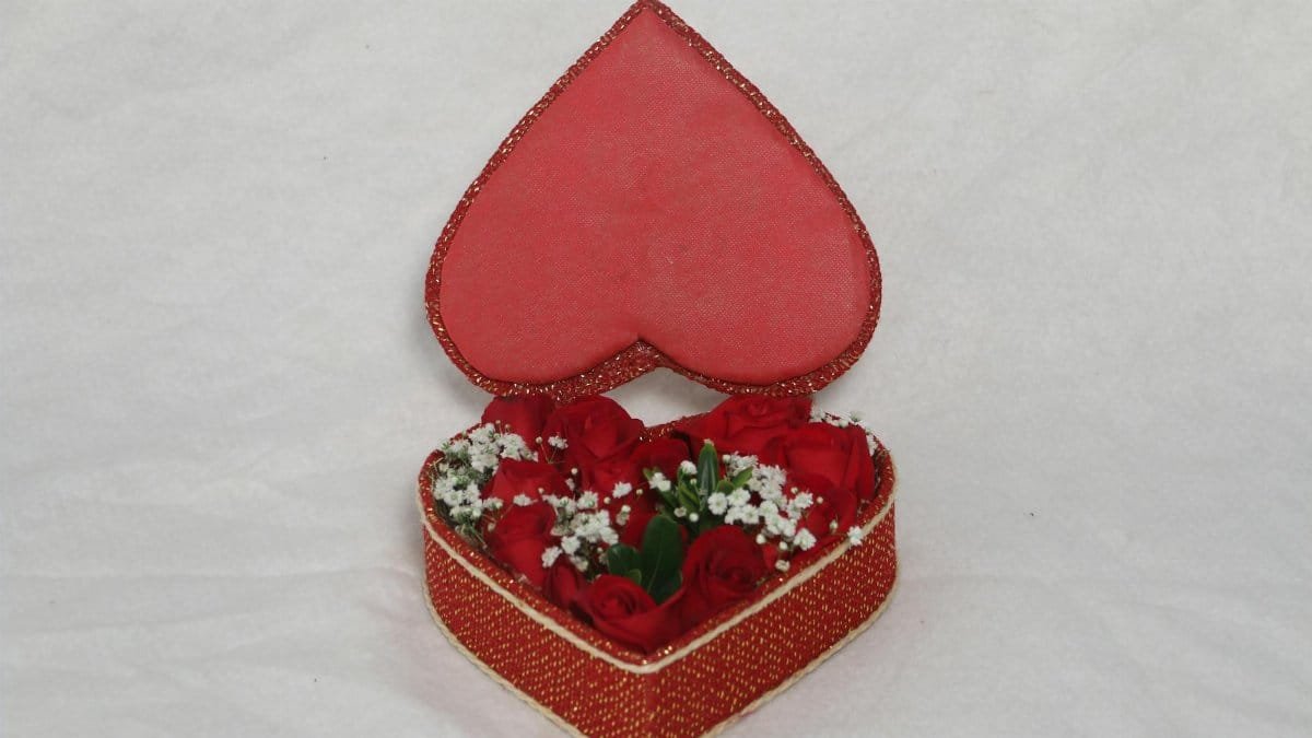 A heart-shaped gift box filled with red roses, ideal for romantic occasions and celebrations.