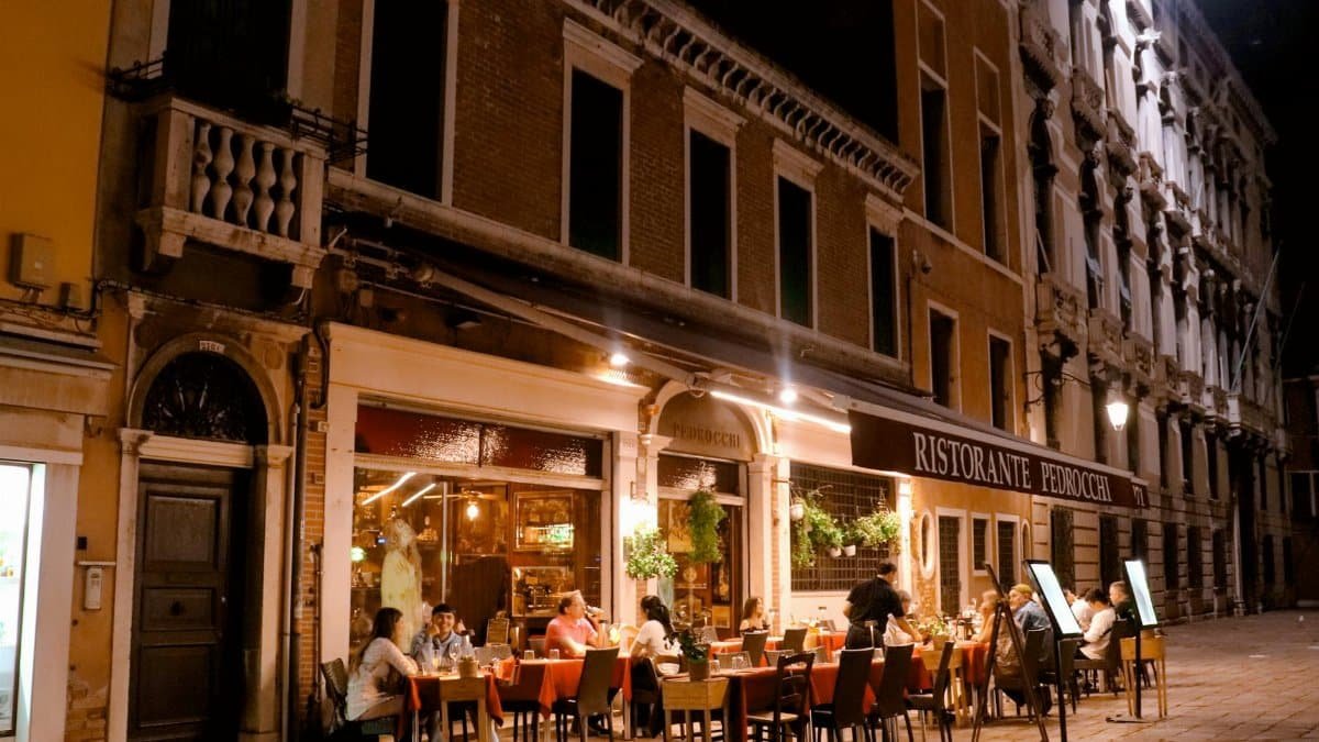 Charming evening ambiance of diners enjoying a meal at Ristorante Pedrocchi in Venice, Italy.