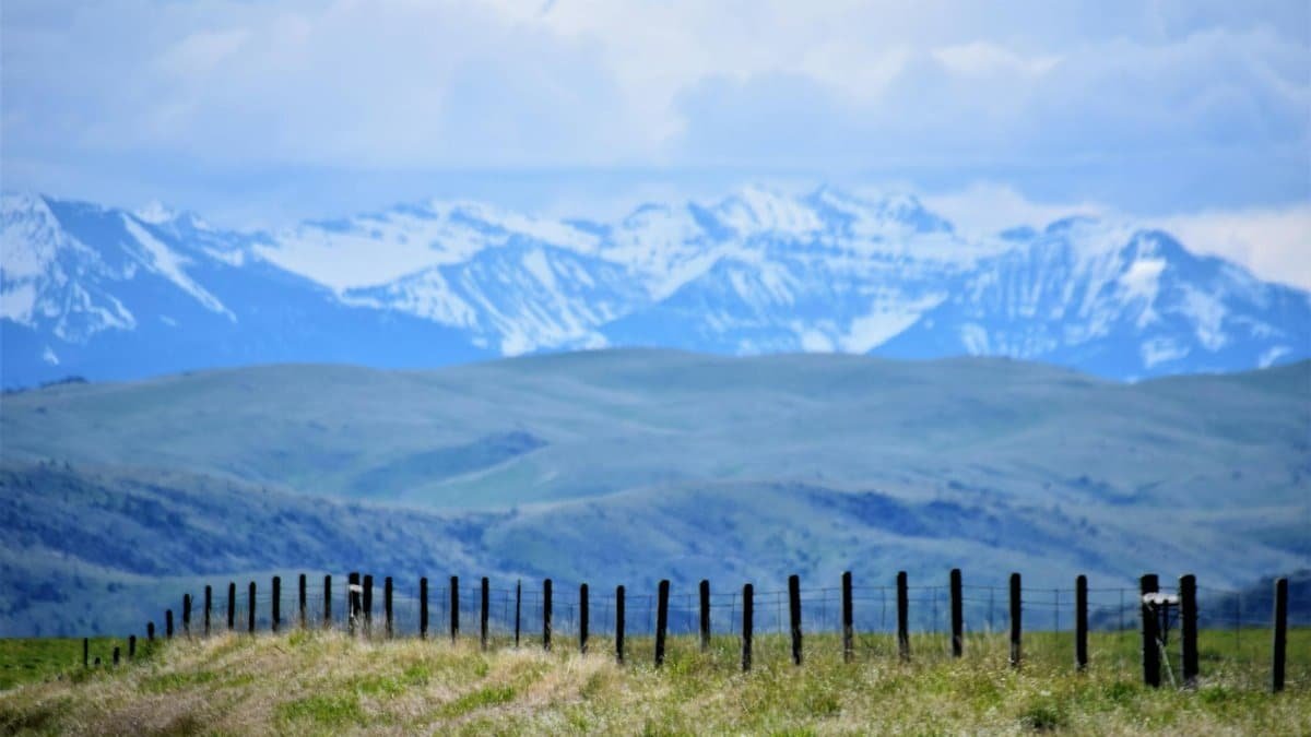 A breathtaking view of the snow-capped mountains and open fields in Harrison, Montana.