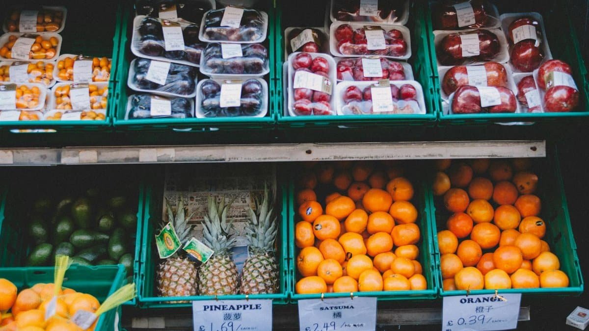 Colorful assortment of fresh fruits displayed in a local market stall with price tags.