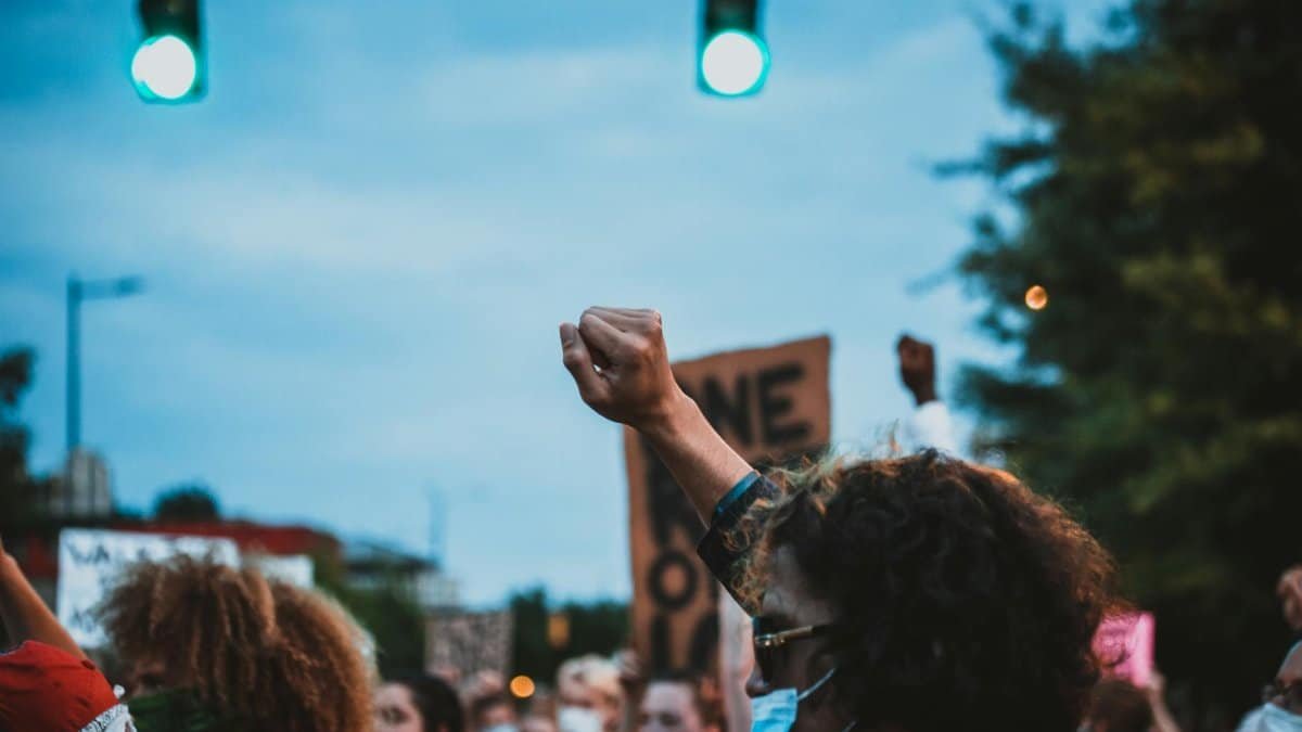 A group of people peacefully protesting with a raised fist, symbolizing unity and demand for change.