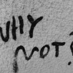 Black graffiti reading 'Why Not?' on a rough wall texture, inspiring curiosity.
