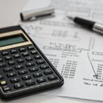 Close-up of financial documents with calculator and pen, ideal for business management themes.