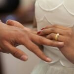 Close-up of a bride and groom exchanging rings during their wedding ceremony, symbolizing love and unity.