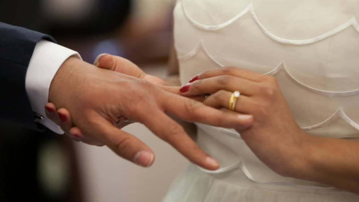 Close-up of a bride and groom exchanging rings during their wedding ceremony, symbolizing love and unity.