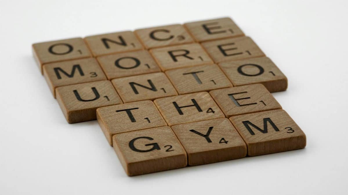 Scrabble tiles forming the motivational phrase 'Once More Unto the Gym' on a white background.