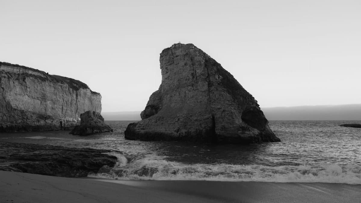 Black and white view of dramatic cliffs on Davenport Beach, California.