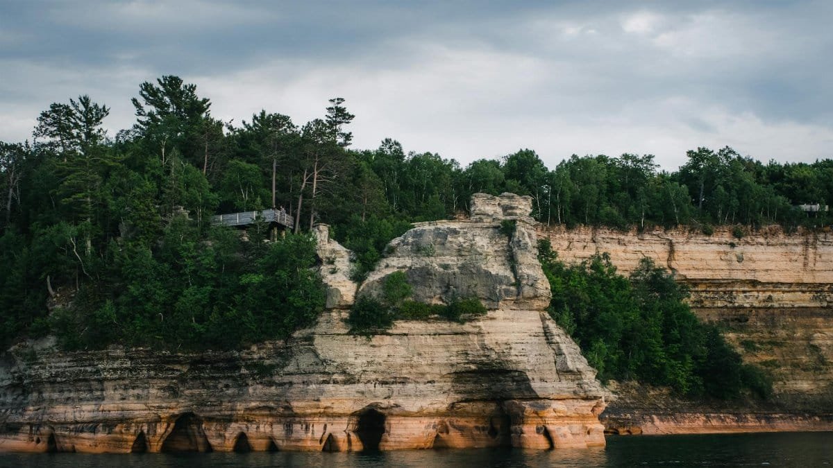 Scenic view of Pictured Rocks cliffs with lush forest above Lake Superior.