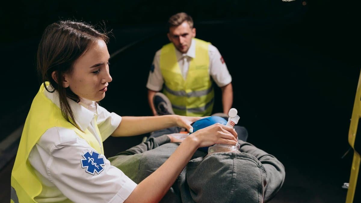 Paramedics provide critical care to a patient during a nighttime emergency response.