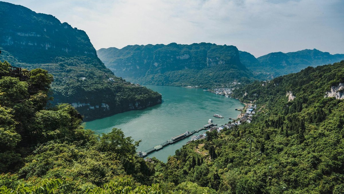 Experience the breathtaking scenery of the Yangtze River gorge with lush greenery and majestic mountains.