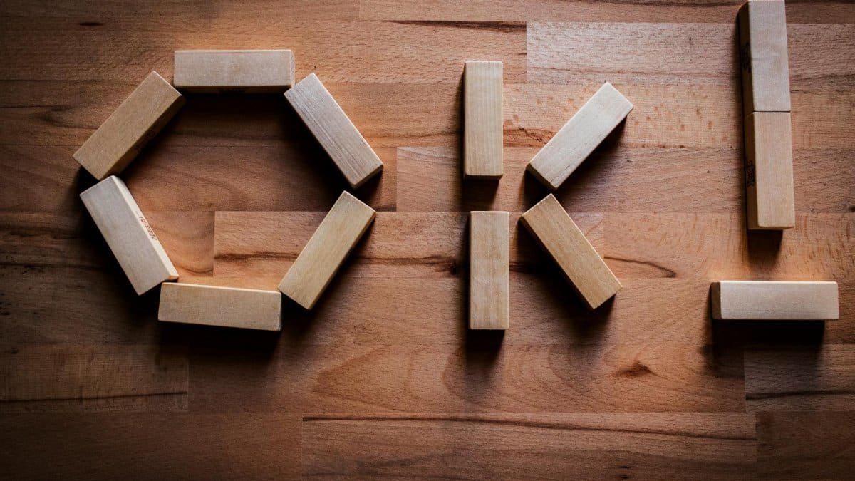 Wooden blocks arranged to spell 'OK' on a wooden tabletop, showcasing creativity in design.