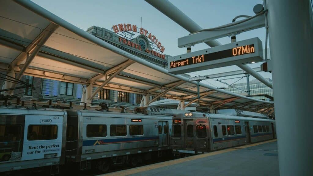 Evening train at Denver Union Station with iconic sign and transit information display.