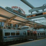Evening train at Denver Union Station with iconic sign and transit information display.