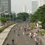 People enjoying a car-free street in a vibrant city setting, ideal for leisurely activities.