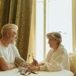 Senior couple using blood pressure monitor at home, fostering health awareness and companionship.
