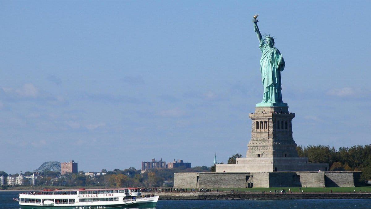 View of the Statue of Liberty with a ferry boat in New York City. Iconic American landmark.