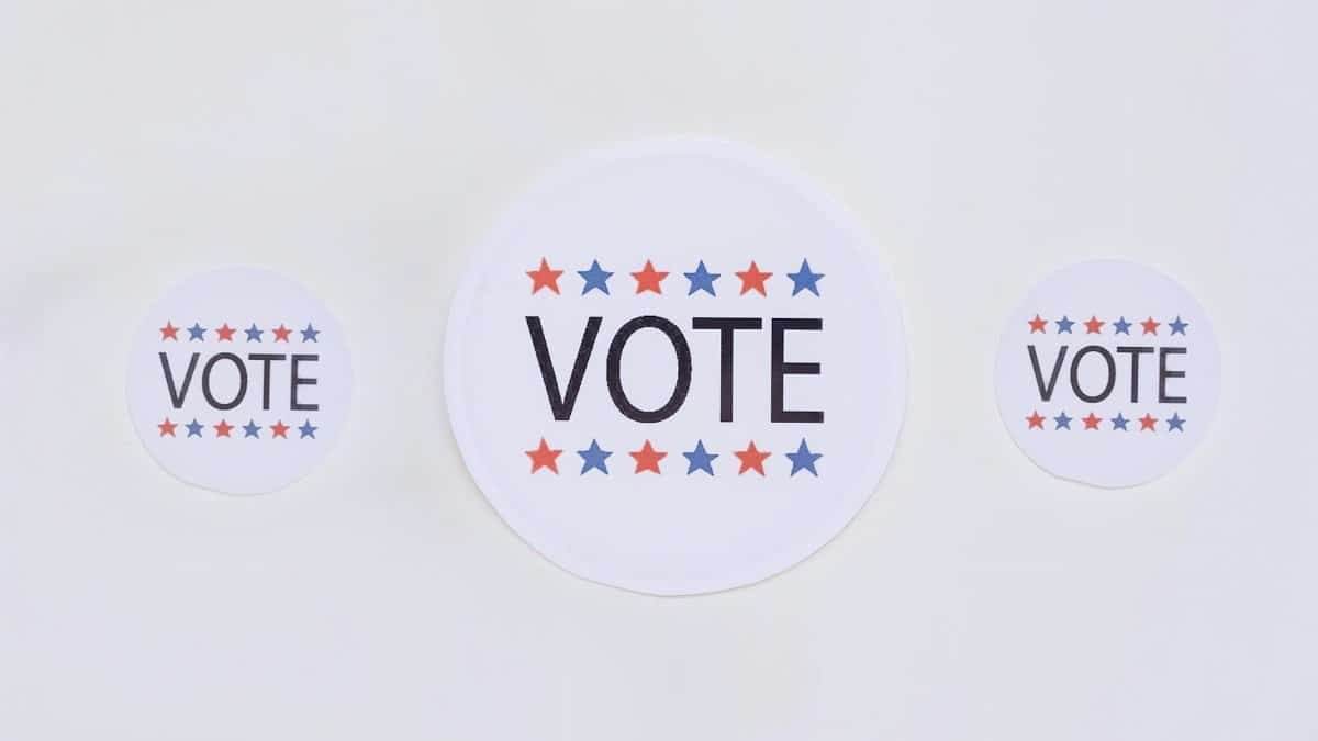 Three vote stickers featuring stars symbolize political participation on a white surface.