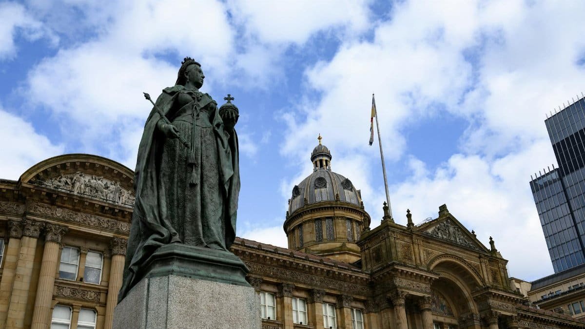 Statue of Queen Victoria outside Birmingham Council House with blue sky background.