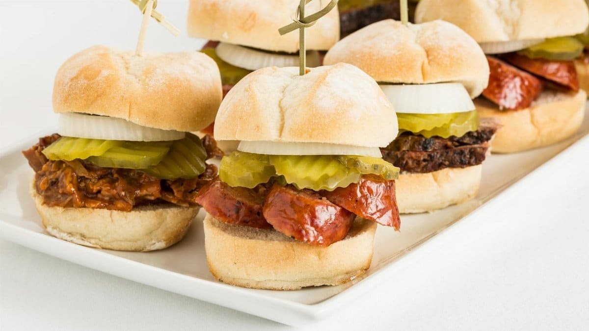 Tasty Texas-style BBQ beef sliders topped with pickles and onions, perfect for parties.