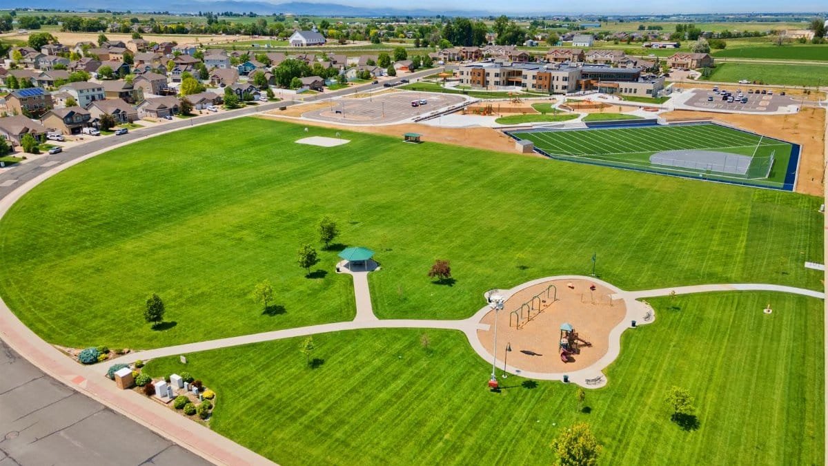 Aerial photograph of a park and playground in Johnstown, CO, showcasing green spaces and urban development.