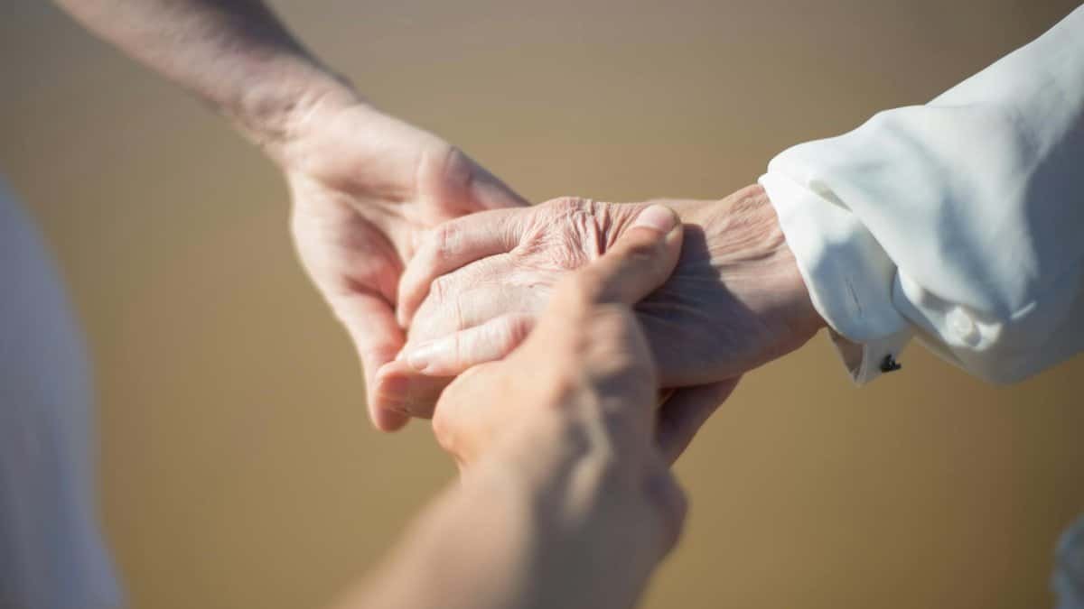 Gentle close-up of intergenerational hands holding, symbolizing connection and care.