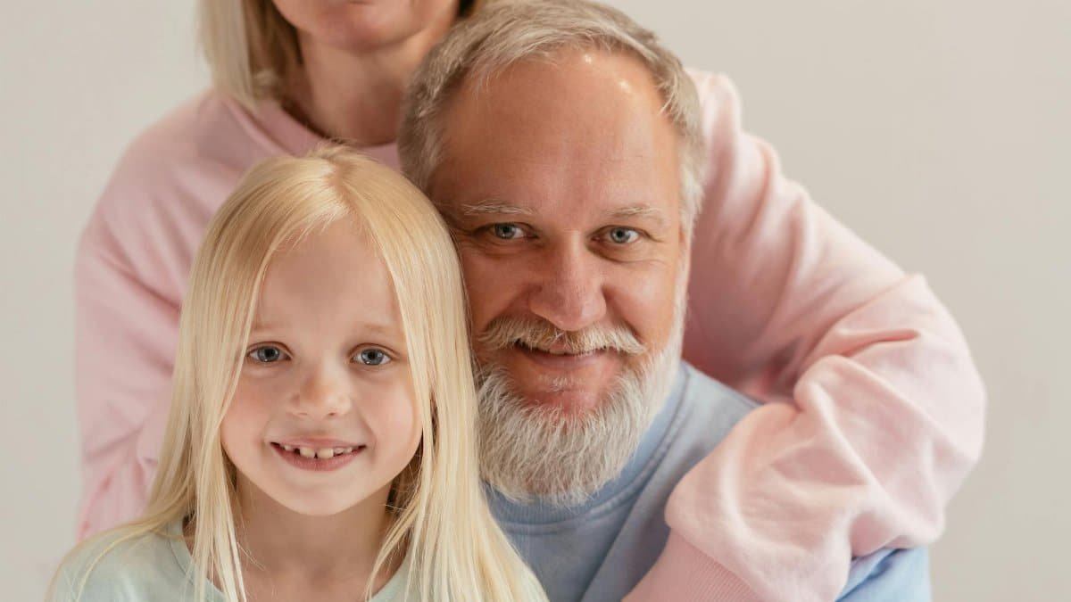 Three generations coming together with warmth and smiles in a studio setting.