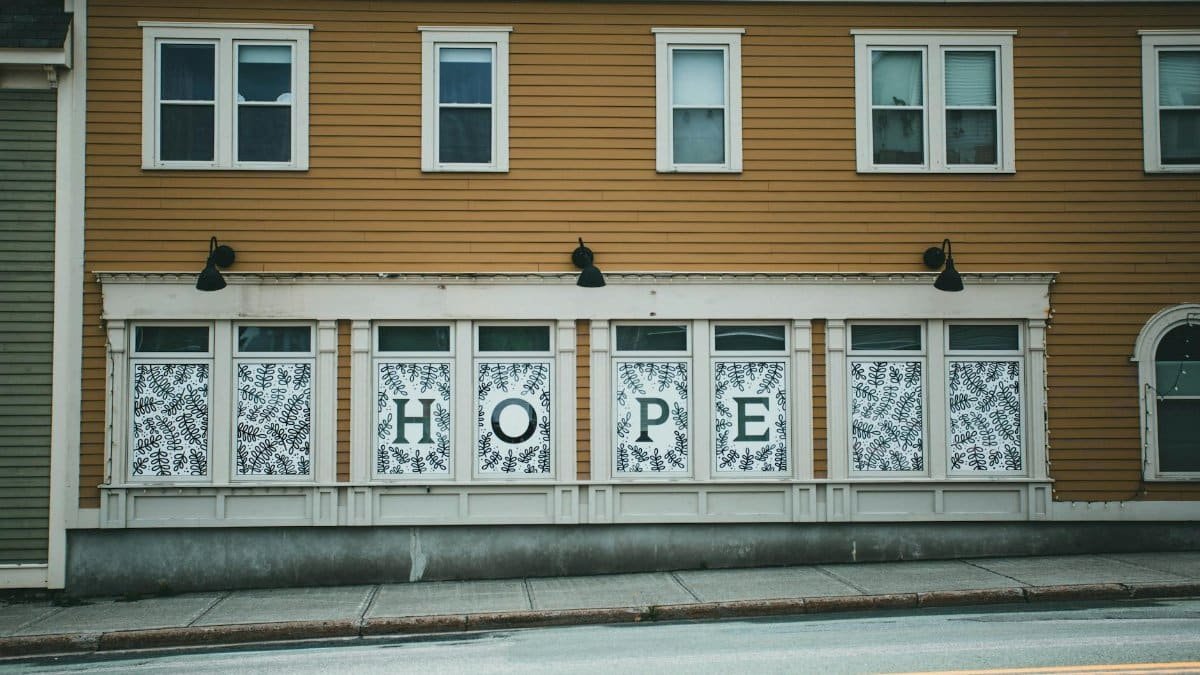 Exterior view of urban building with 'HOPE' sign on windows, creating an inspiring atmosphere.