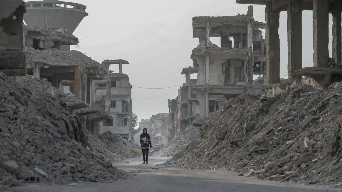 A solitary figure walks through the devastated ruins of Damascus, Syria, highlighting the aftermath of conflict.