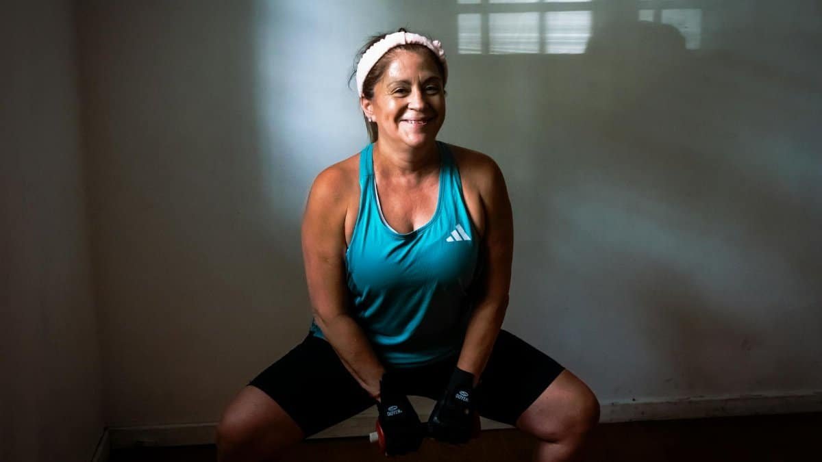 Healthy woman working out indoors with dumbbells, promoting fitness and strength.