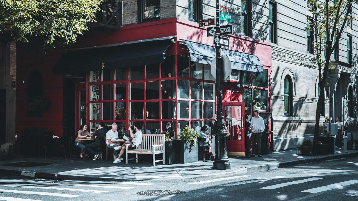 Casual outdoor dining at a vibrant red cafe corner in New York City.