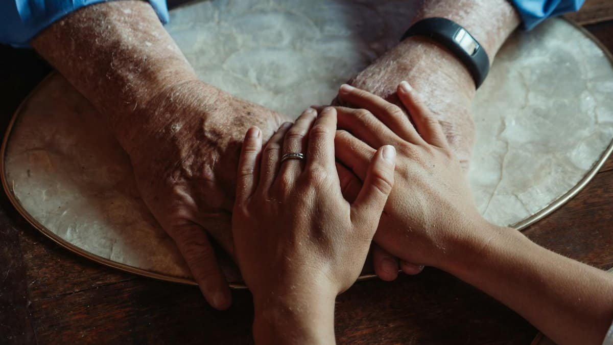 Close-up of elderly and young hands joined, symbolizing compassion and support.
