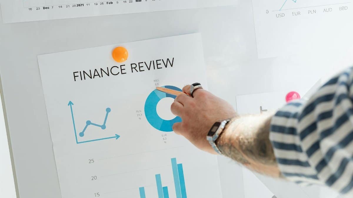 Close-up of a hand pointing to financial charts during a business review.