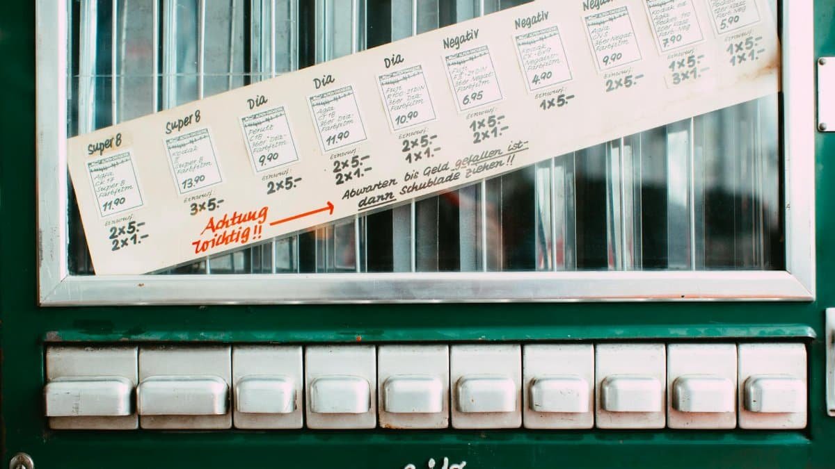 Vintage vending machine featuring German instructions and multiple white buttons.