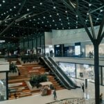 Explore a spacious and contemporary shopping mall featuring trendy shops, lush greenery, and stylish architecture.