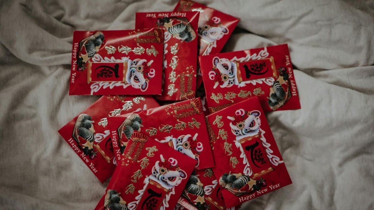 A collection of vibrant red envelopes for Chinese New Year celebration on a soft fabric surface.
