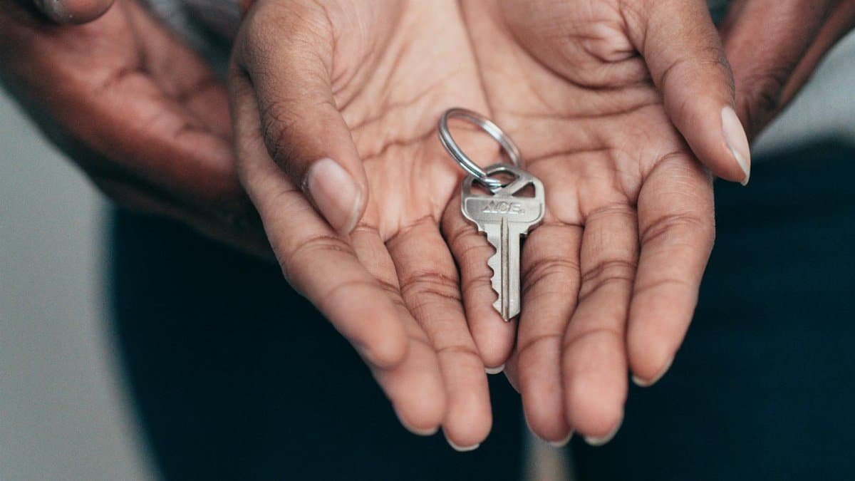 Close-up of hands holding a key, symbolizing homeownership, real estate, and property investment.