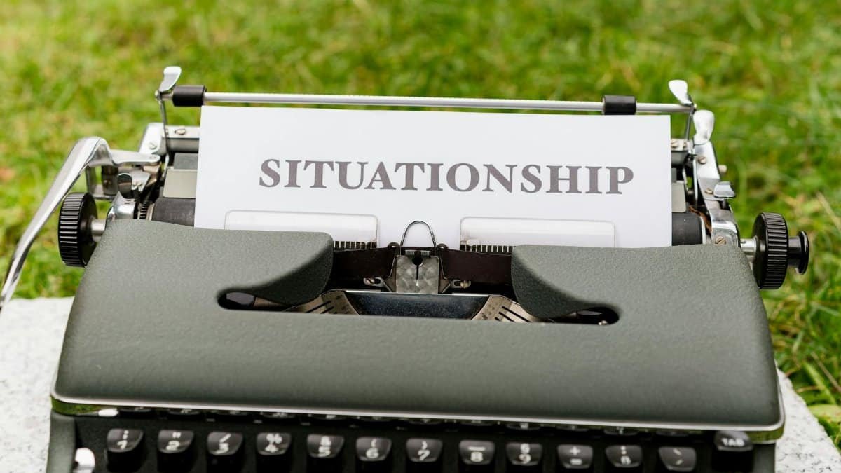 Close-up of a vintage typewriter with the word 'Situationship' typed on paper outdoors.