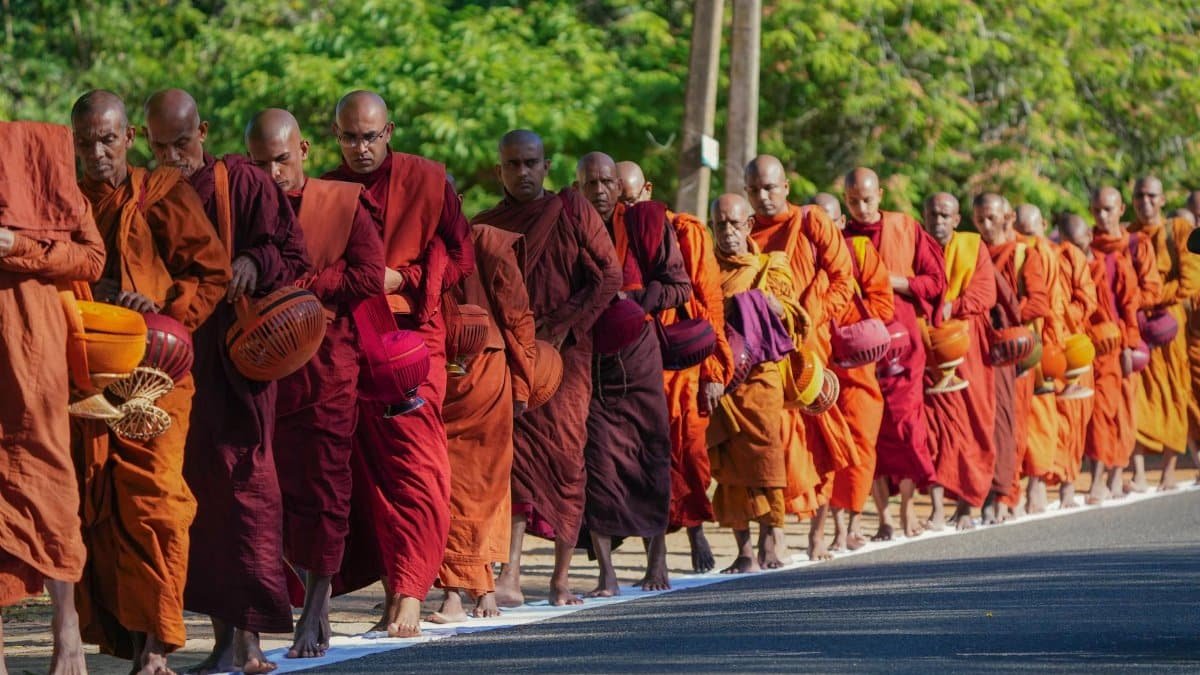 Monks in vibrant robes participate in a spiritual pilgrimage on a sunny day in Sri Lanka.