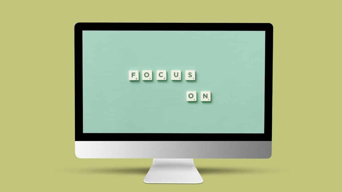 Computer monitor with 'Focus On' message using Scrabble tiles on screen for motivation and focus.