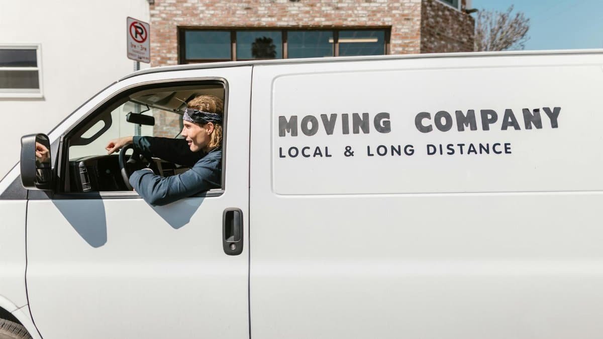 Driver in a moving company's van providing local and long-distance services.