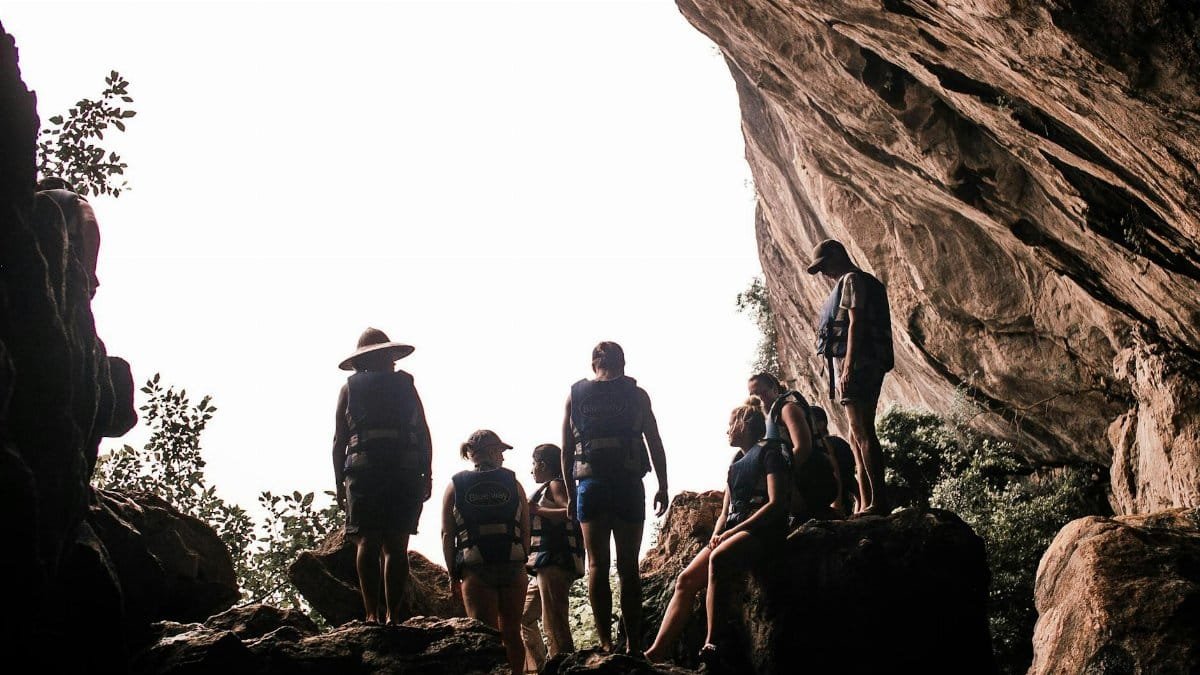 A diverse group standing inside a large natural cave, capturing the essence of adventure.